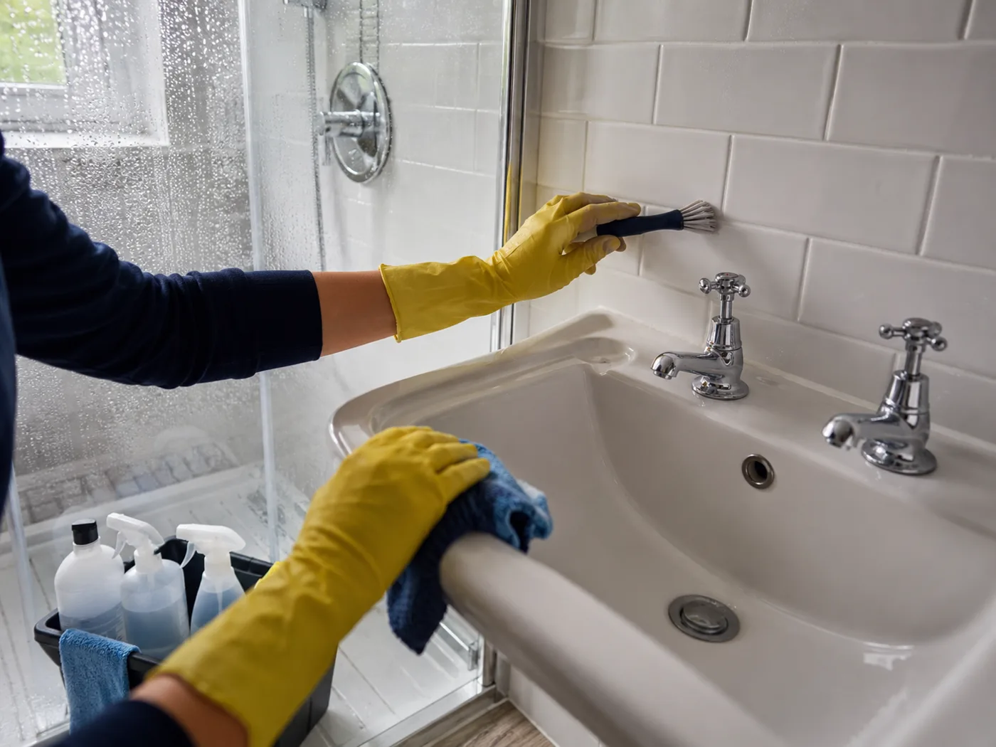 Deep cleaning a bathroom, scrubbing tiles and removing limescale